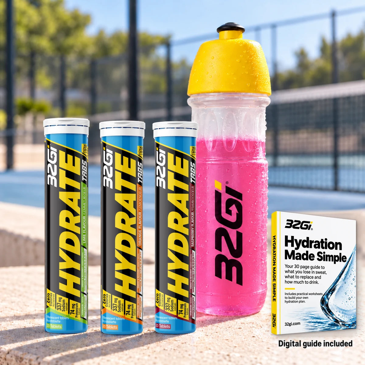 Three 32Gi Hydrate tubes in Lime, Orange and Raspberry, a 32Gi bottle of pink Hydrate and the Hydration Made Simple guide, on a sports court