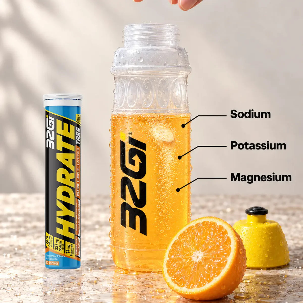 A Hydrate tablet fizzing in a wide-mouth 32GI bottle beside the Hydrate Lime tube, labelled sodium, potassium and magnesium